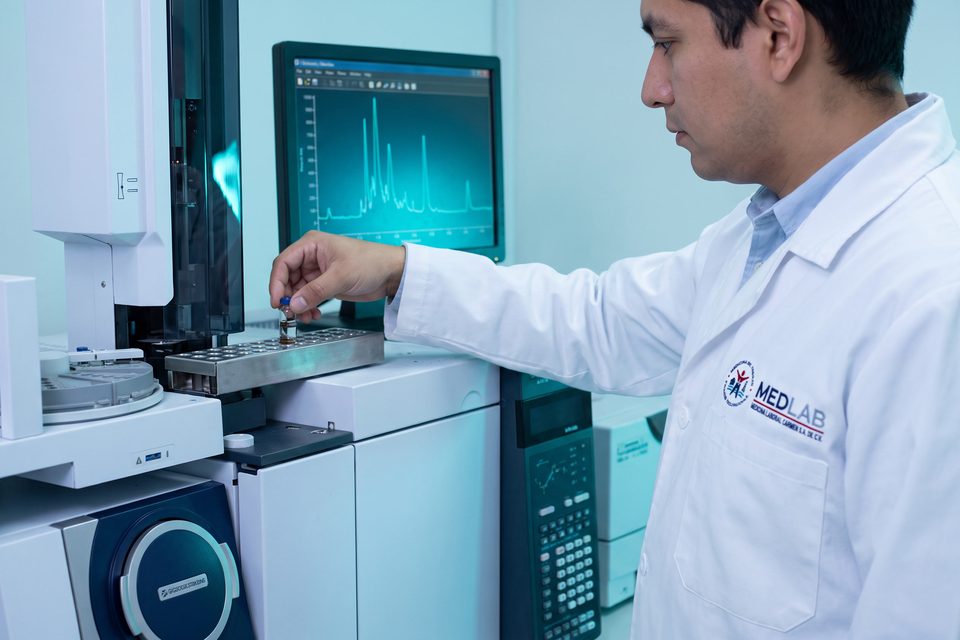 Analista de laboratorio MEDLAB carga un vial en el cromatógrafo de gases acoplado a espectrometría de masas